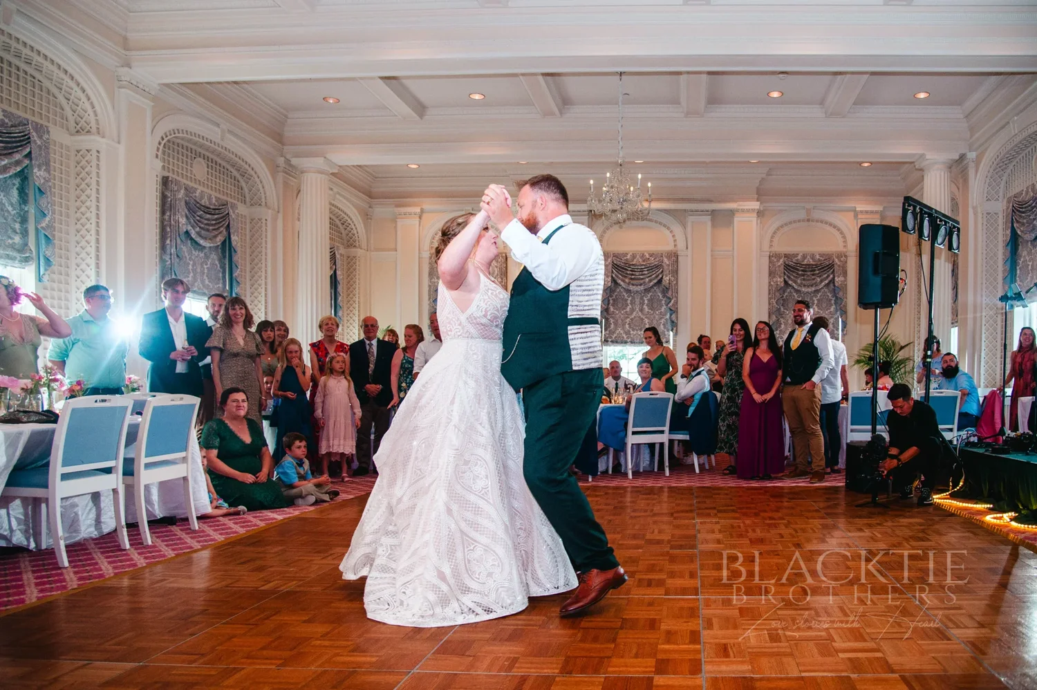 Amanda and Chris dancing in the ballroom surrounded by their guests at The Otesaga