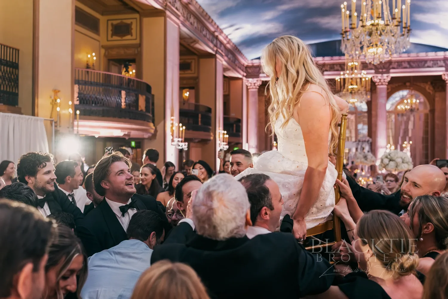 Catie lifted above a crowd of dancing guests beneath the painted ceiling at Marriott Syracuse Downtown