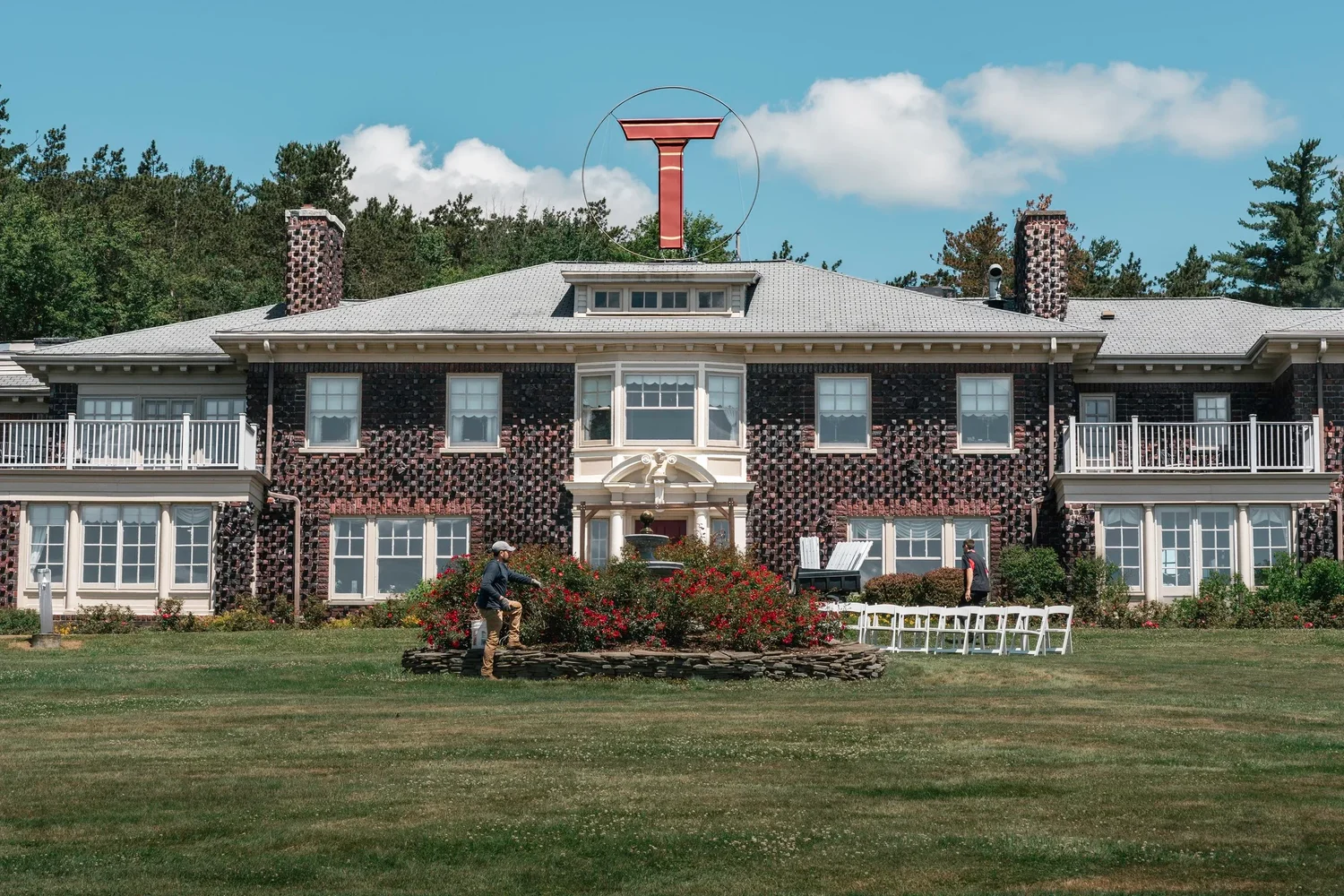 The brick mansion at Traditions at the Glen in Johnson City, New York, seen across the front lawn under a blue sky