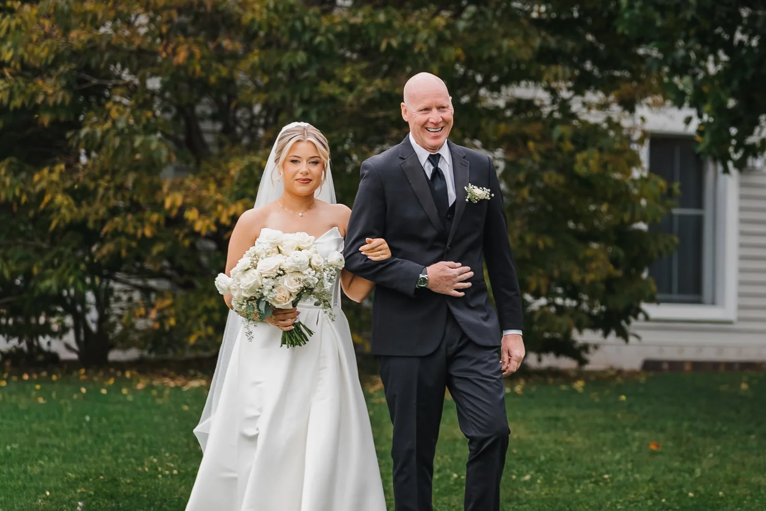 Bride and her escort walking toward the outdoor ceremony at Stonewall Estate