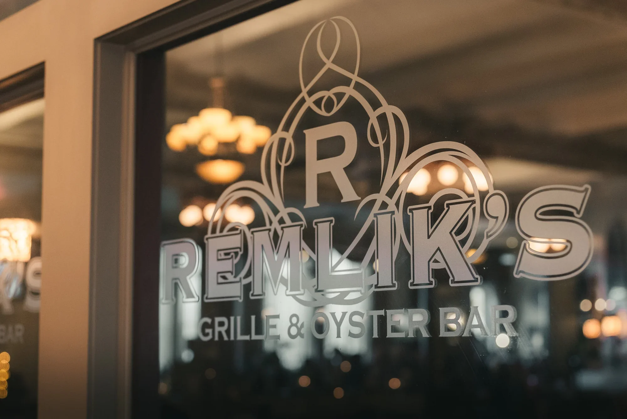Remlik’s Grille & Oyster Bar lettering on the etched glass entrance.