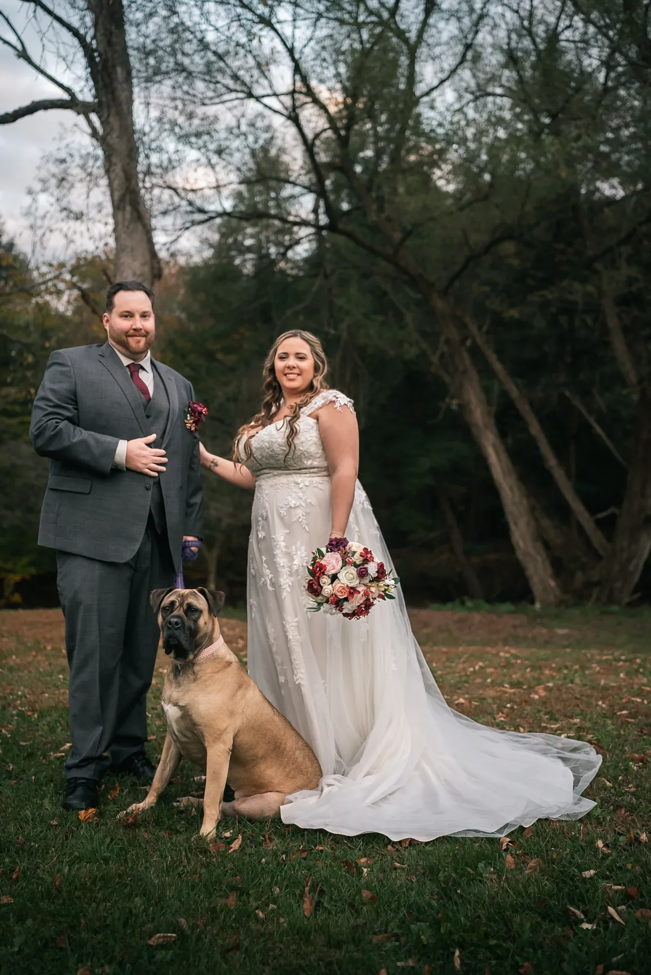 Newlyweds with their dog on the grounds at Stoney Creek Castle