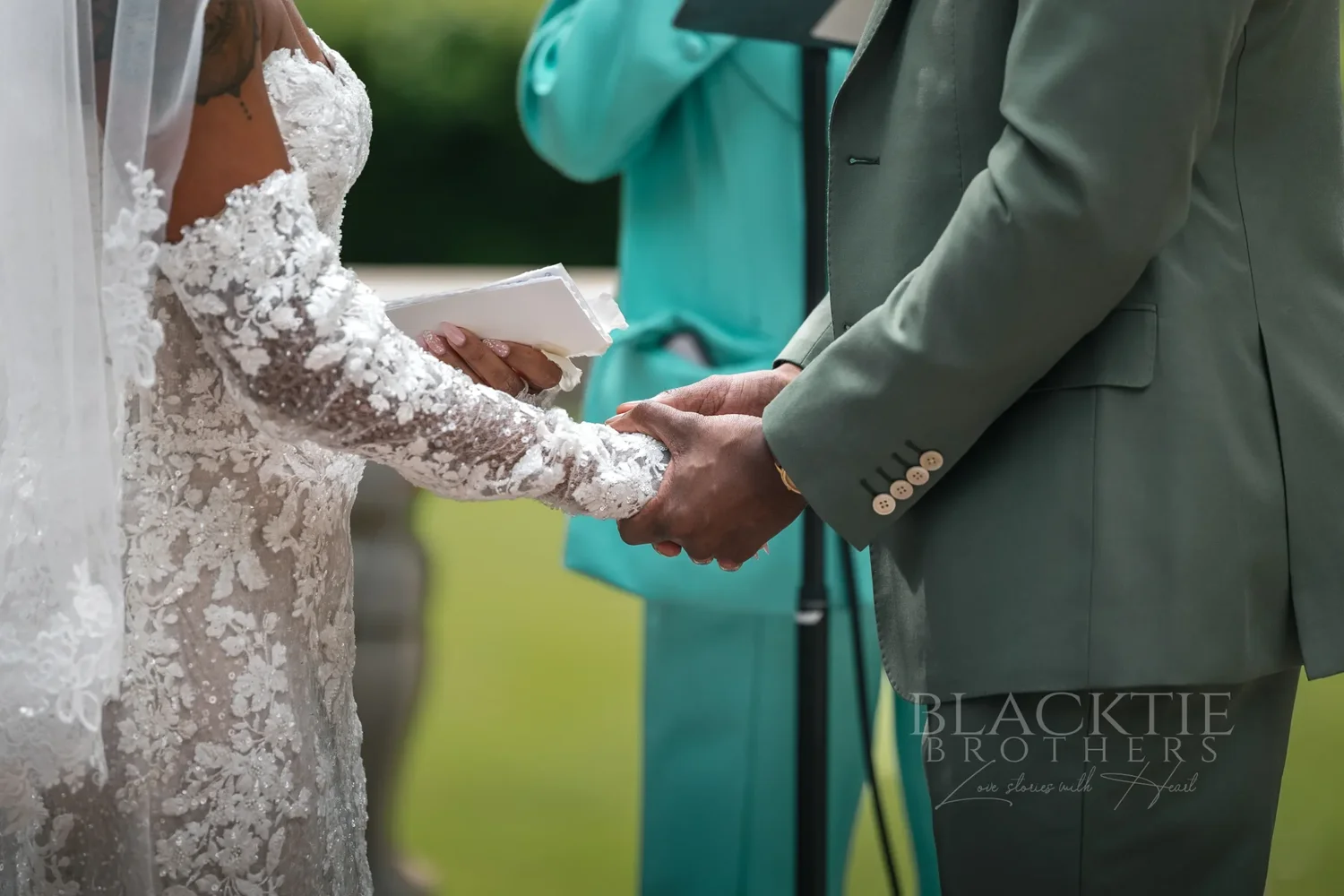 Close-up of the bride and groom holding hands during the ceremony