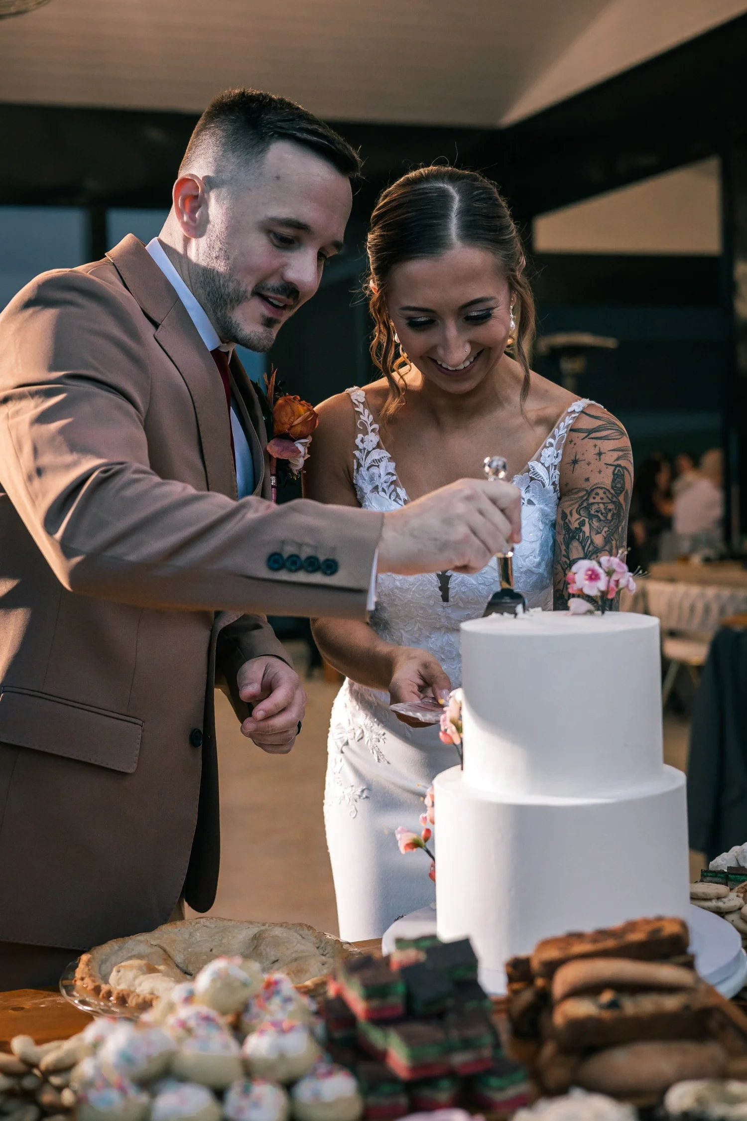 Heather and Vincent cutting a white wedding cake together