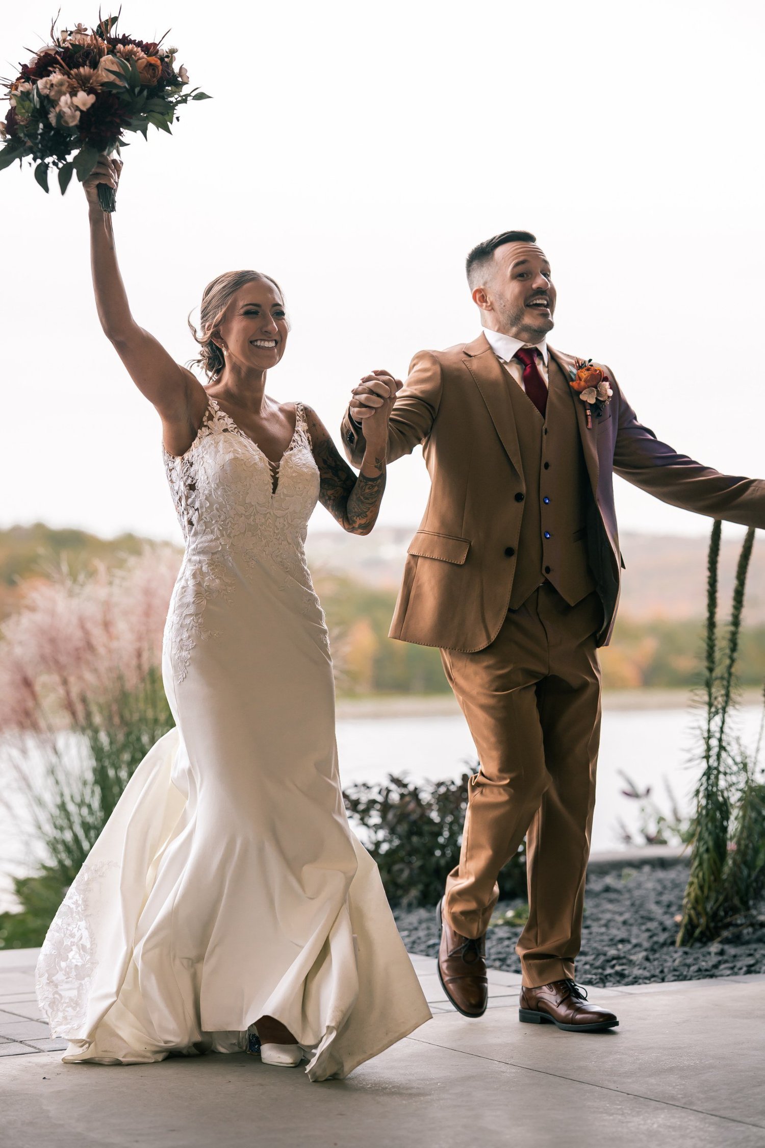 Heather and Vincent making their grand entrance, Heather holding her bouquet in the air
