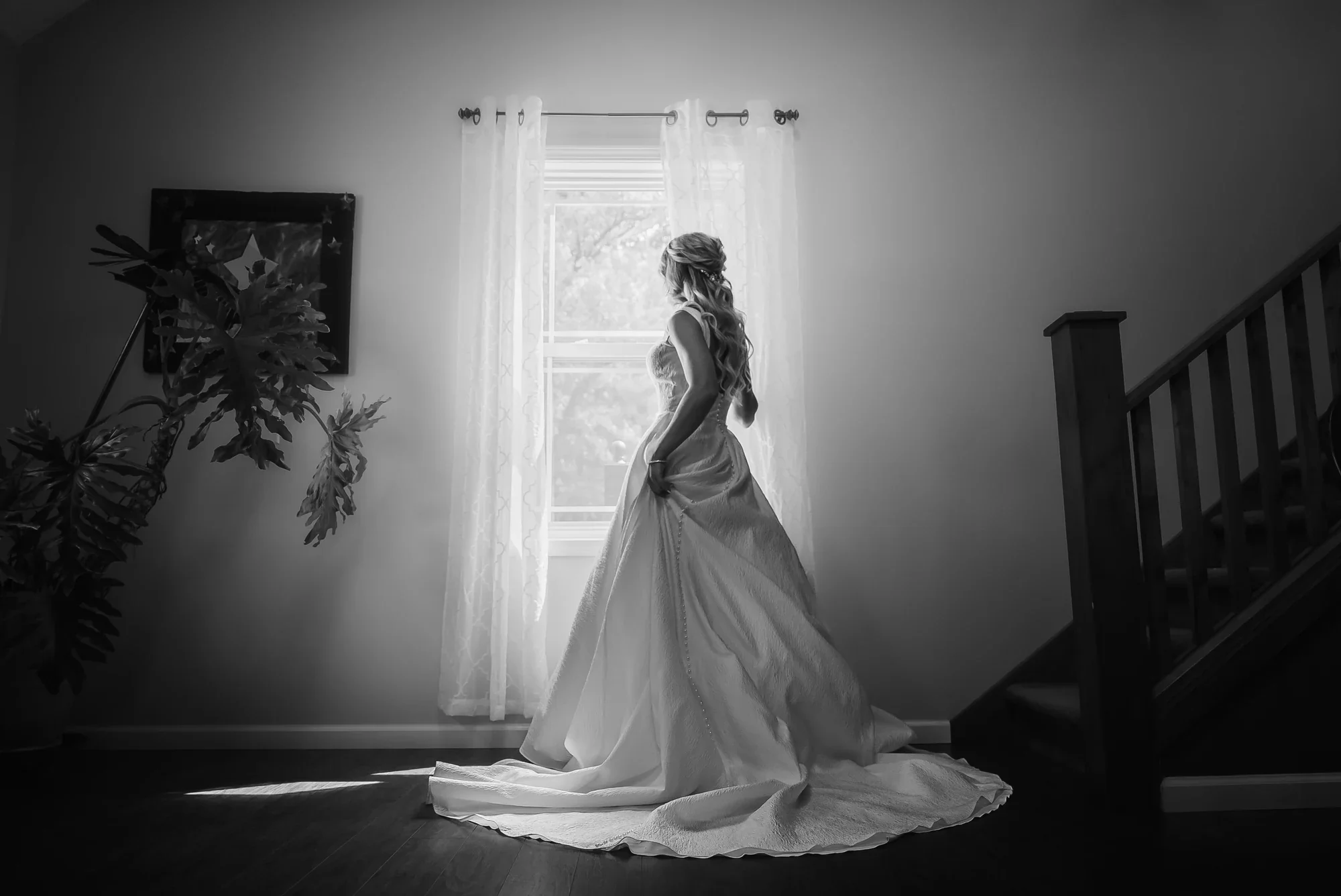 Bride in window light beside the staircase inside the on site house at LedgeRock.