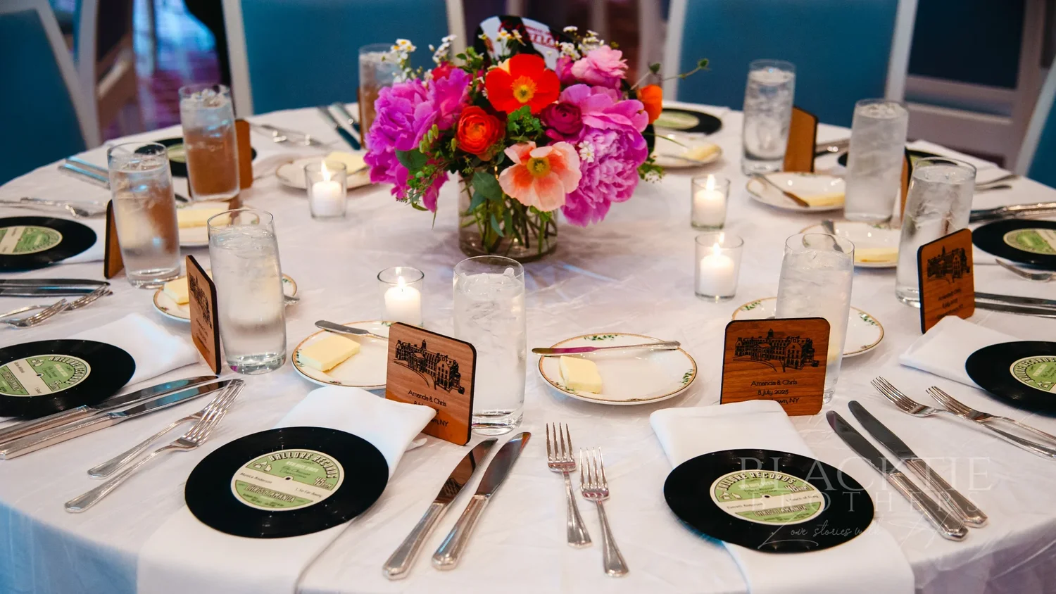 Reception table set with candles and pink and red flowers at The Otesaga
