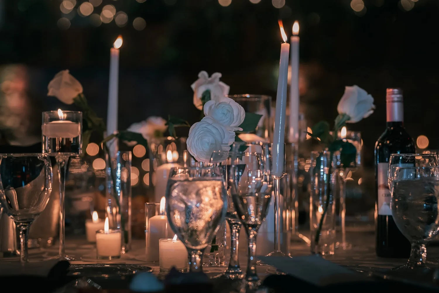 A reception table set with candles, glassware and white flowers at The Somerley.