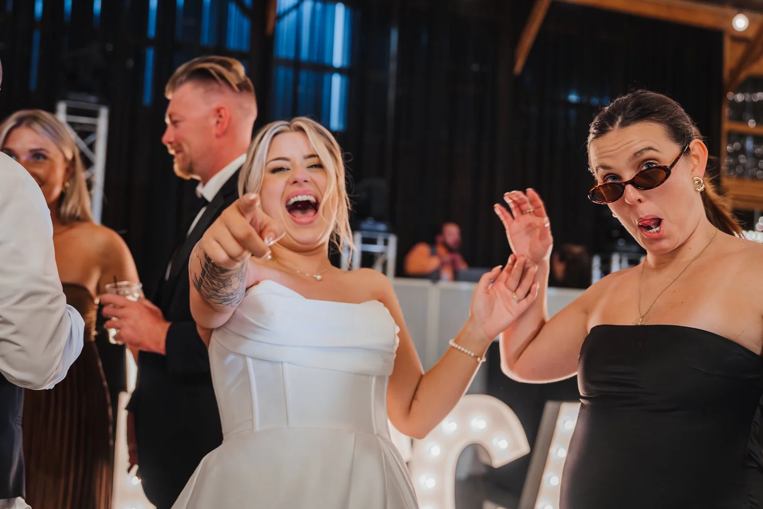 Bride laughing with guests on the dance floor inside Stonewall Estate's barn