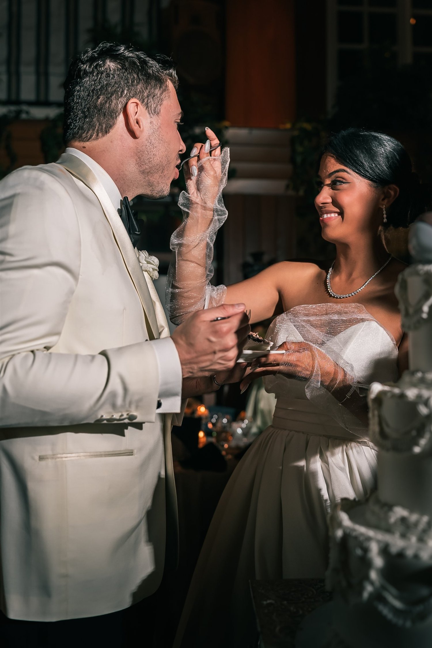 Patricia smiles as she shares a bite of wedding cake with Joshua during the reception.