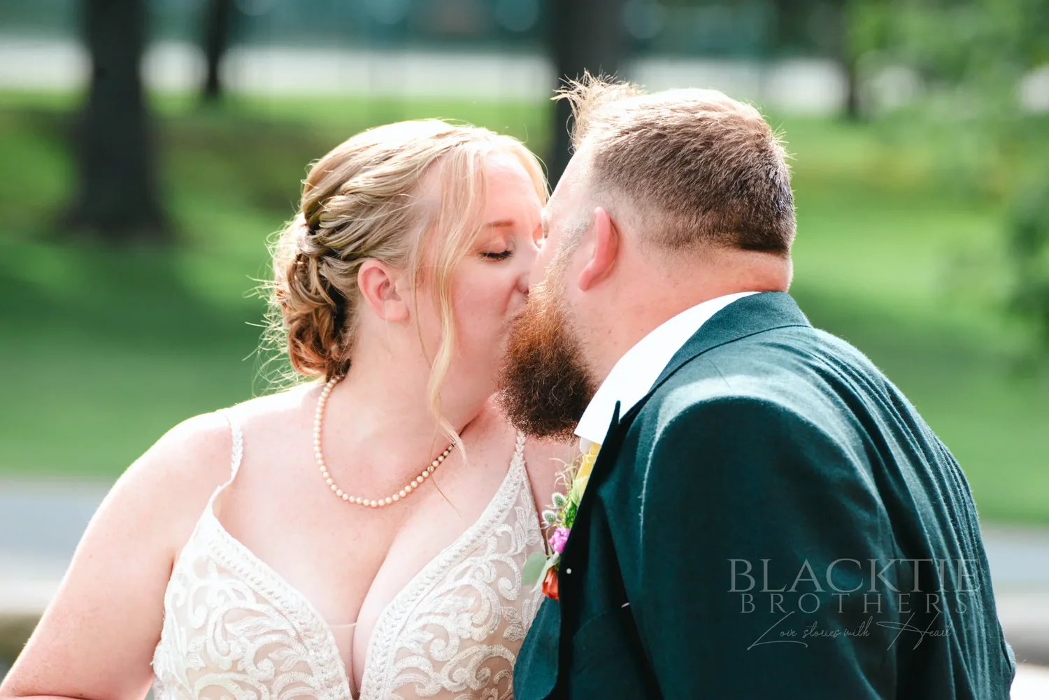 Close portrait of Amanda and Chris kissing on The Otesaga grounds