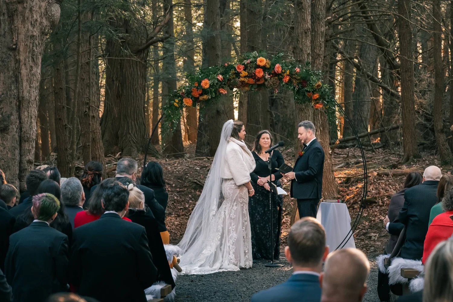 Charissa and Andrew exchanging vows beneath the trees at Windham Manor