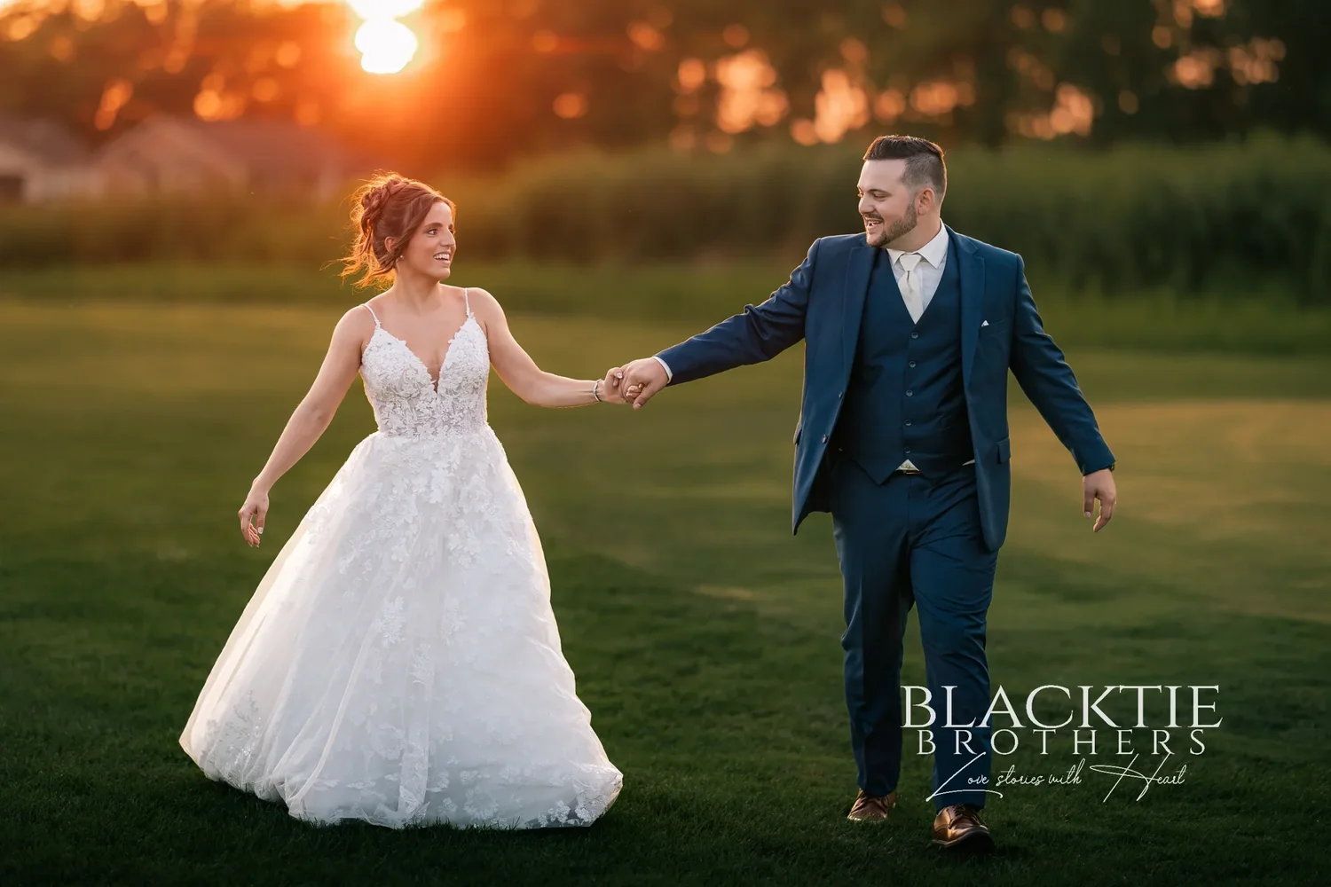 Taylor and Jake walking hand in hand across a fairway at Timber Banks as the sun sets behind the trees