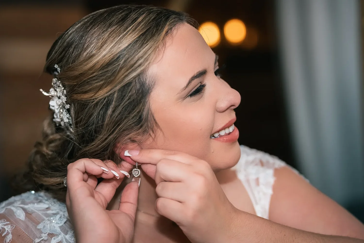 Bride fastening an earring while getting ready at Stoney Creek Castle