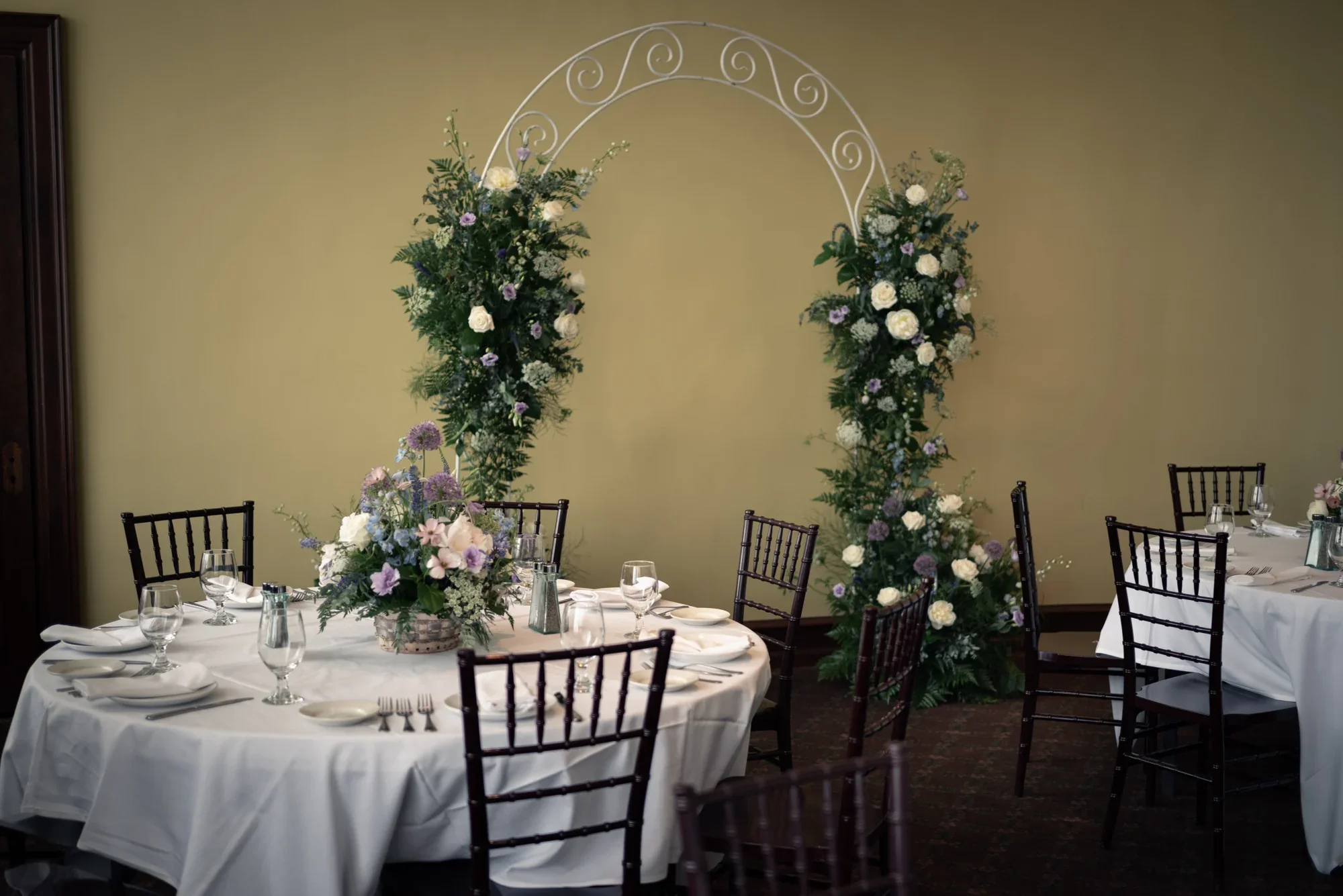 Dining tables and a floral ceremony arch set for Kealy and Jimmy’s Remlik’s wedding.