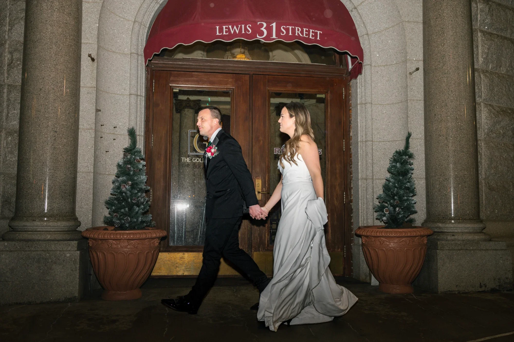 Mackenzie and David walk hand in hand past the 31 Lewis Street entrance of the Kilmer Building.
