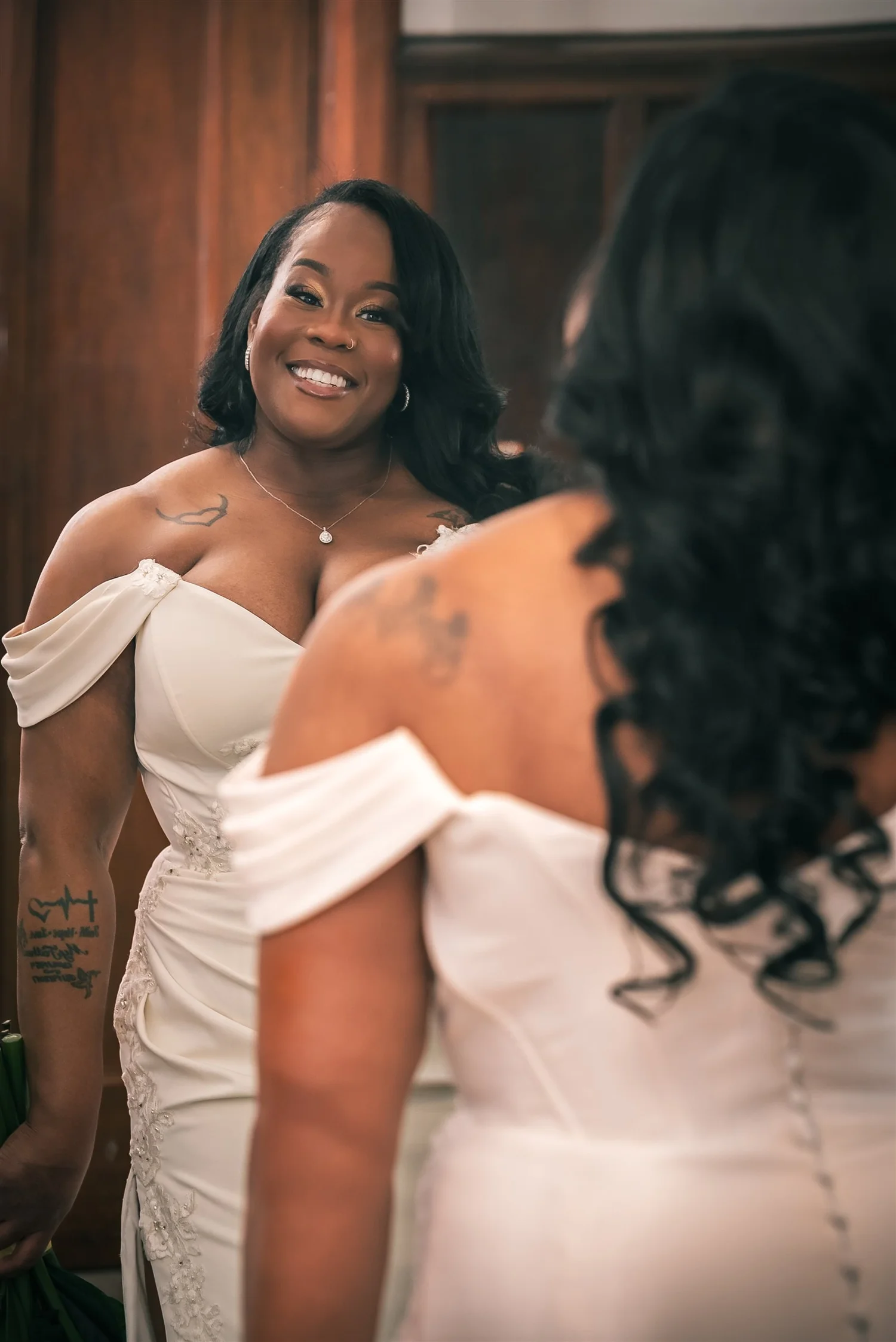 Tiffany smiles at her reflection in a gold-framed mirror.