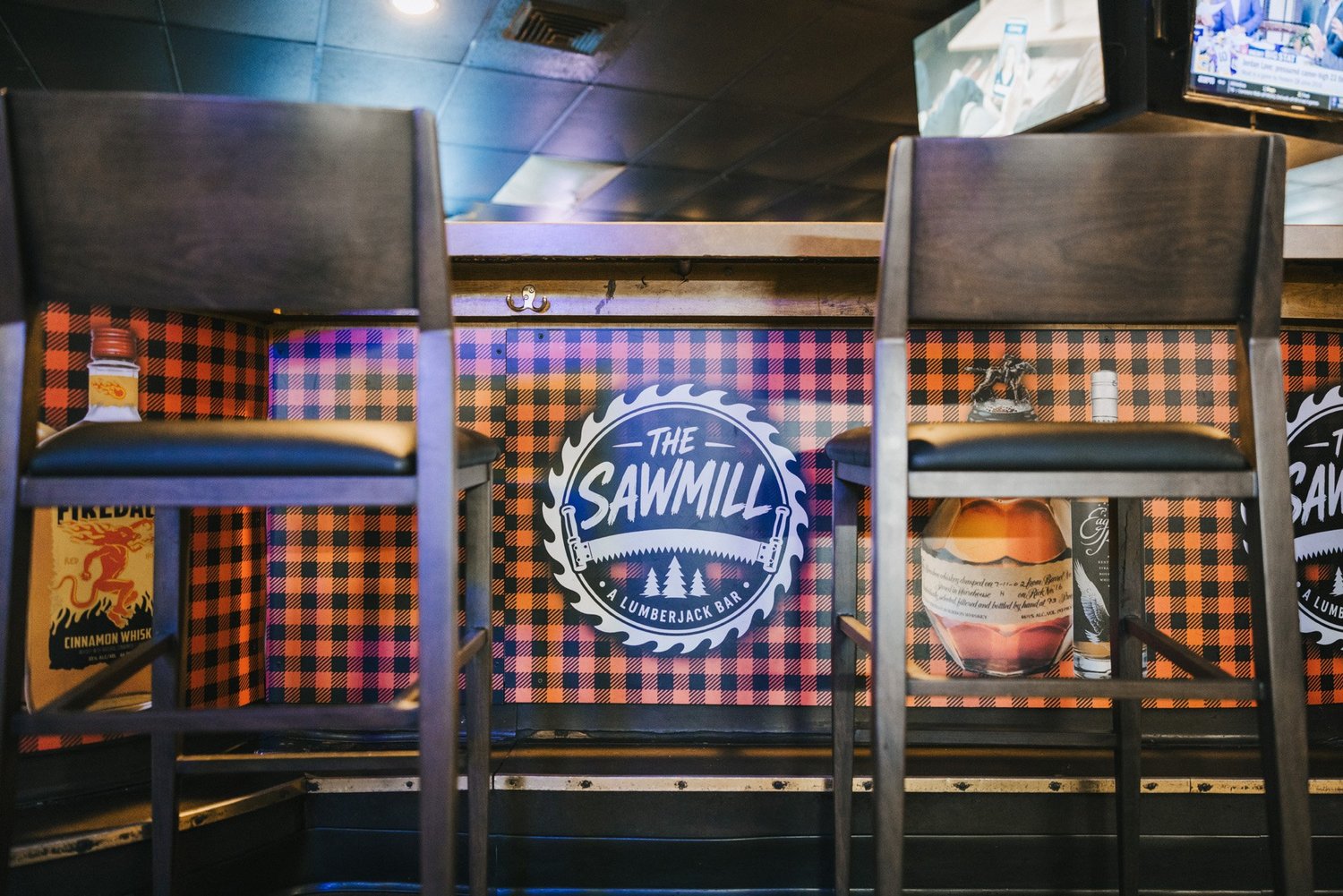Bar stools and plaid bar front at The Sawmill in Tampa