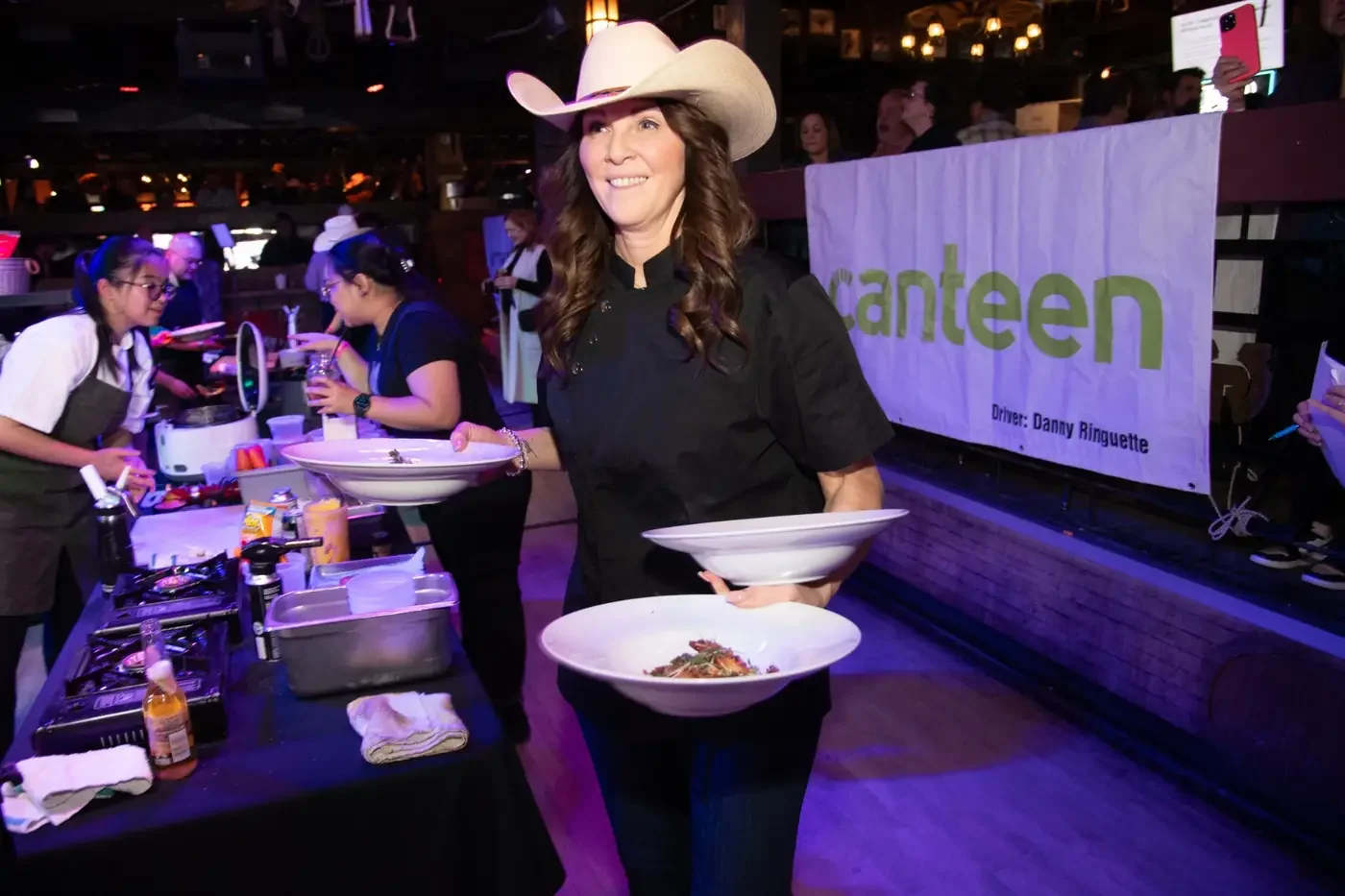 Chef carrying plated dishes during a Brakemen fundraising event