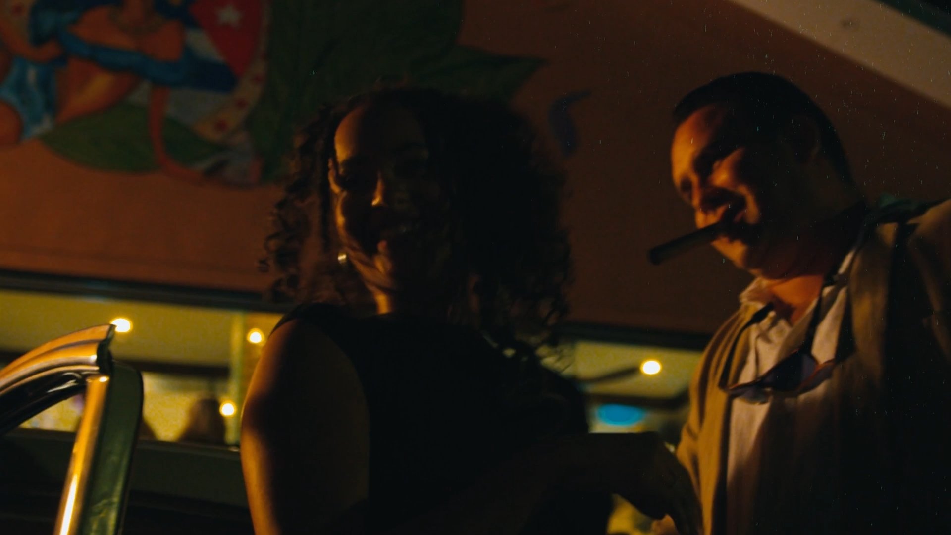 Woman getting out of car with man with a cigar