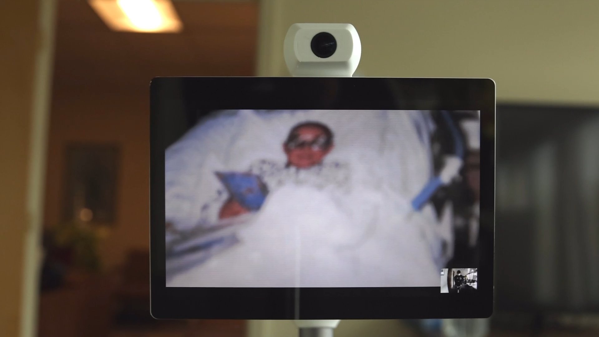 Tablet with webcam on person in hospital bed