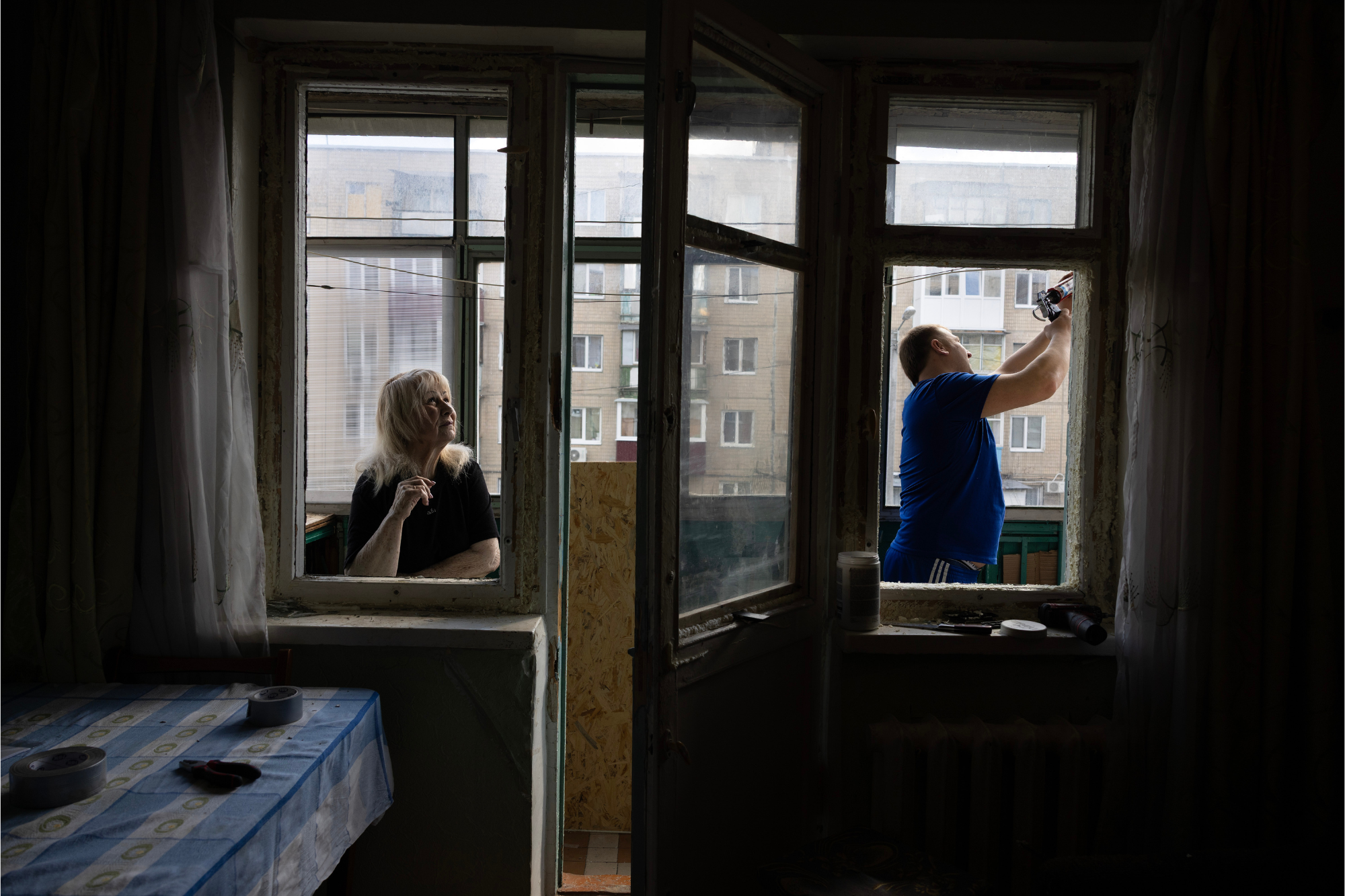 Insulate Ukraine installing a window in a home affected by the war