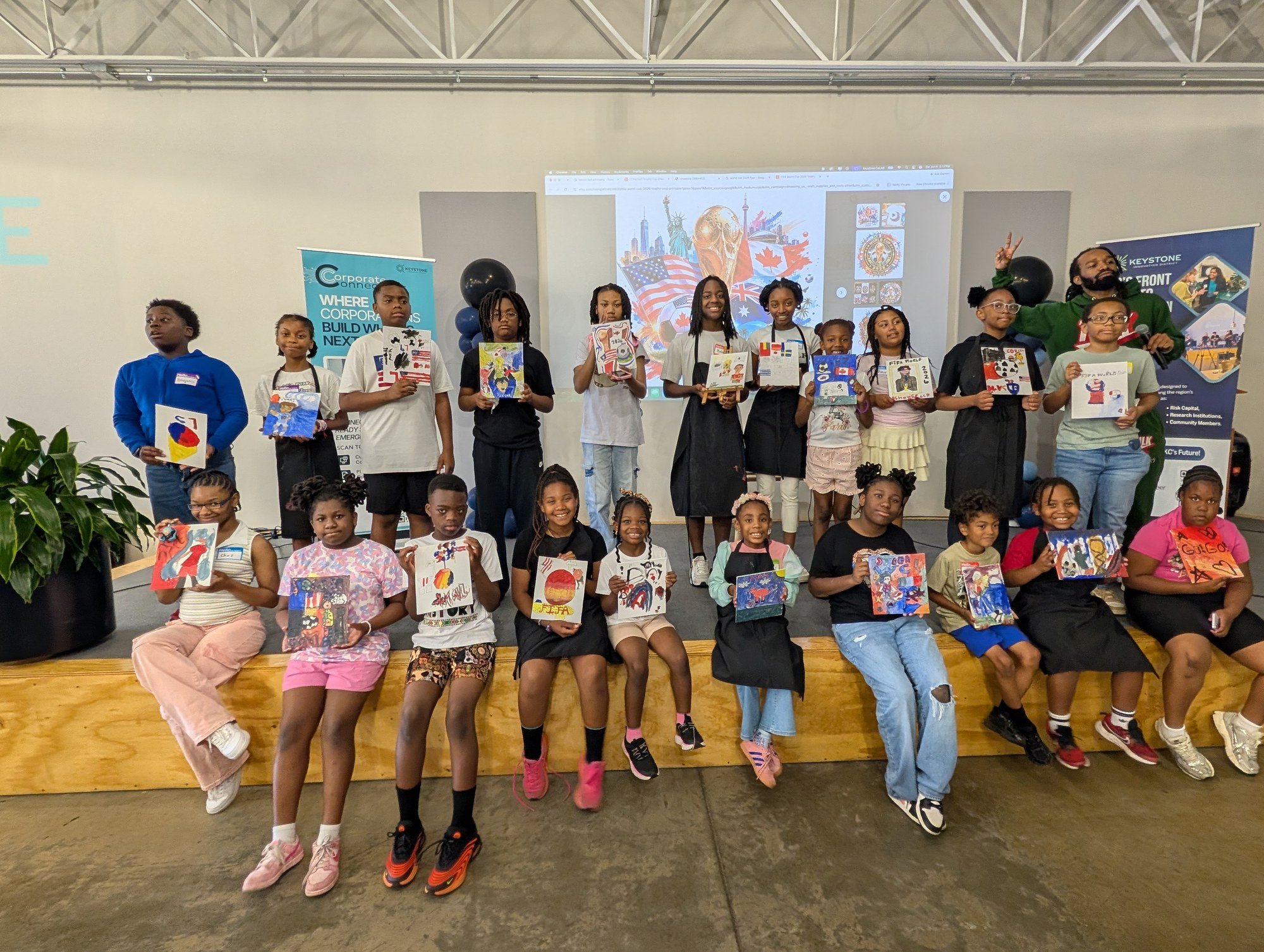 Young artists and instructors display their finished artwork at a previous YAI session.