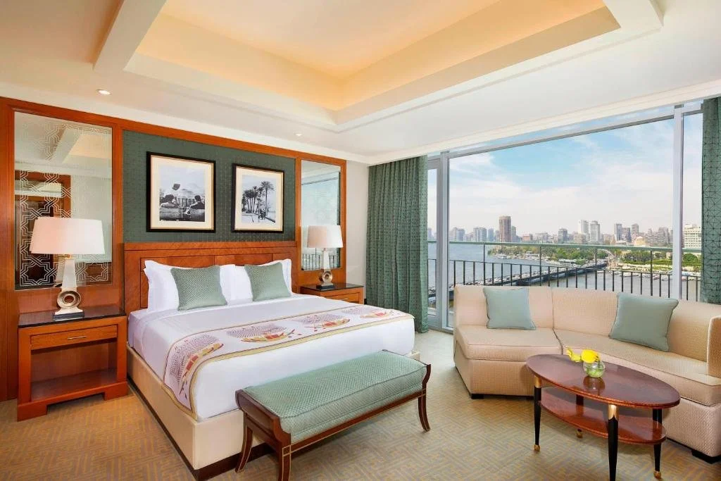 The Nile Ritz-Carlton Cairo suite sitting area with floor-to-ceiling Nile River view and Zamalek island skyline