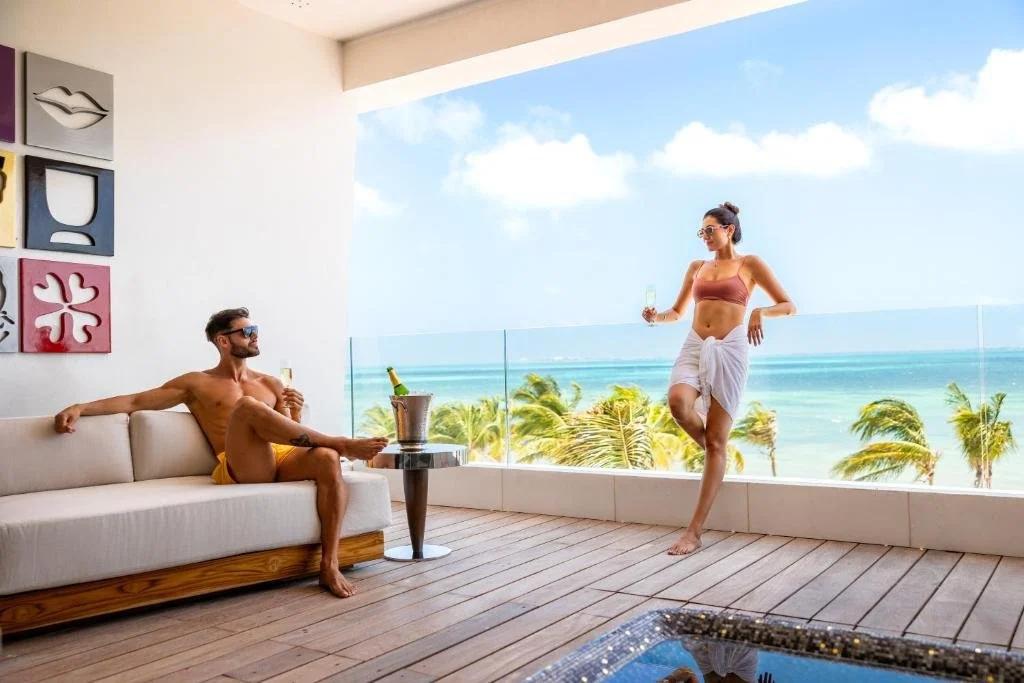 Hotel Mousai Cancun Ocean Front suite terrace with plunge pool, contemporary art wall, and Caribbean Sea view through glass balustrade