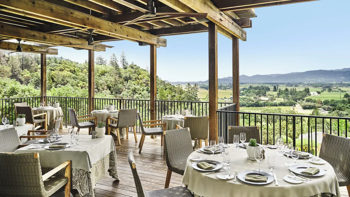 Auberge du Soleil Napa Valley open-air restaurant terrace with round dining tables overlooking vineyards and valley floor