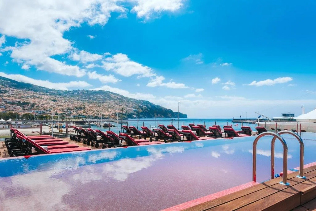 Pestana CR7 Funchal rooftop pool with view over the marina harbor and Funchal hillside