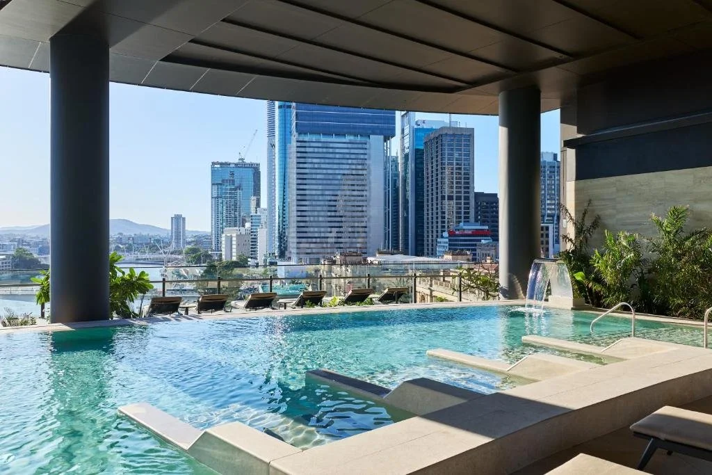 The Star Grand Brisbane Brisbane Leisure Deck infinity pool with waterfall feature and Brisbane CBD skyline and river views
