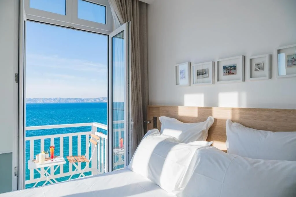 Les Bords de Mer Fontenille Collection Marseille sea-view room with open balcony door and blue Mediterranean horizon