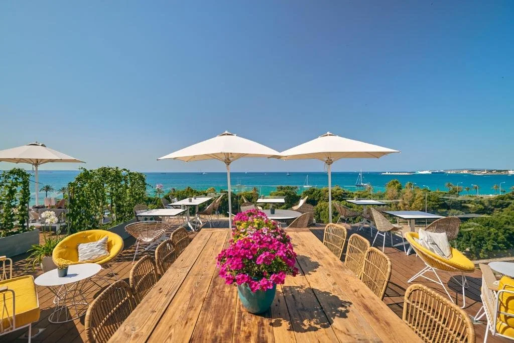 Es Princep Palma rooftop terrace with wooden deck and parasols overlooking the turquoise Bay of Palma