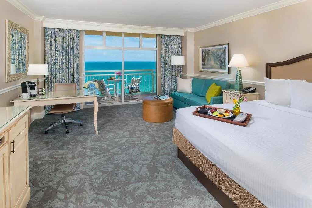 The Shores Resort and Spa Daytona Beach oceanview king room with floral curtains and balcony facing the Atlantic Ocean