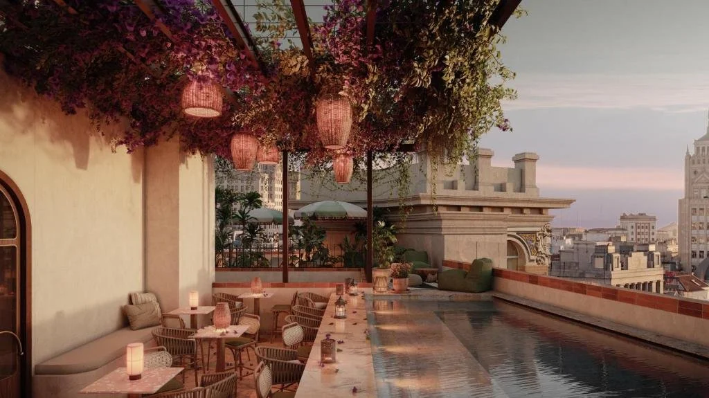 Hotel Nômade Madrid rooftop bar and pool at dusk with floral pergola and Gran Vía skyline view at sunset