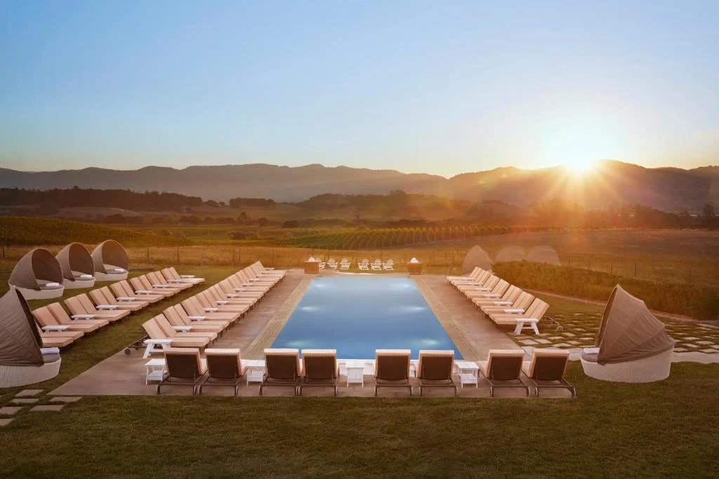 Carneros Resort and Spa Napa outdoor pool at sunset with symmetrical loungers and vineyard and mountain panorama