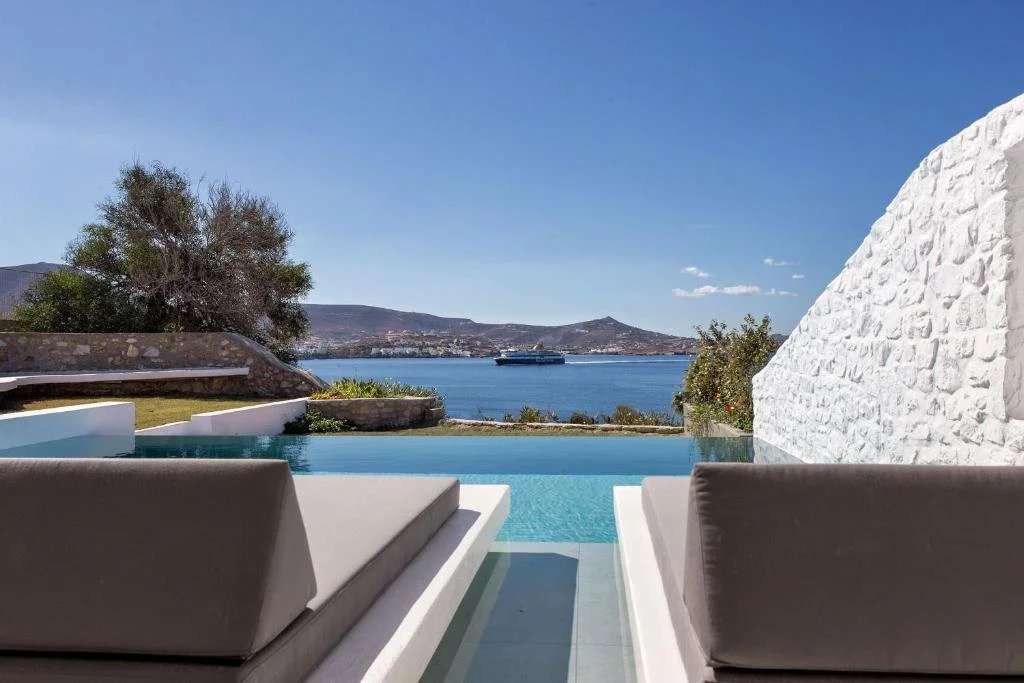 Paros Agnanti Resort Spa Paros illuminated infinity pool at dusk overlooking harbor with town lights and island hills