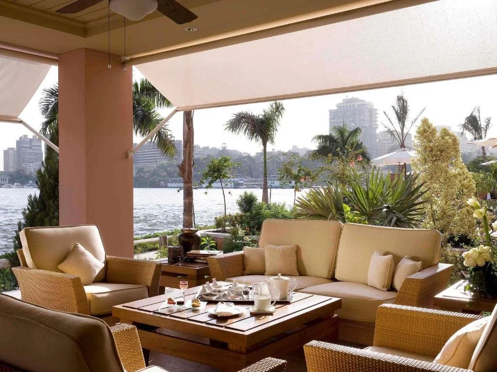 Sofitel Cairo Nile El Gezirah open-air riverside terrace with rattan seating and palm trees overlooking the Nile