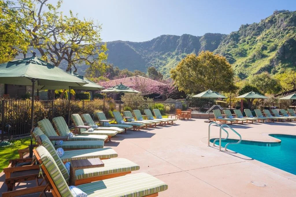 The Ranch at Laguna Beach outdoor pool with lounge chairs and Aliso Canyon hillside backdrop