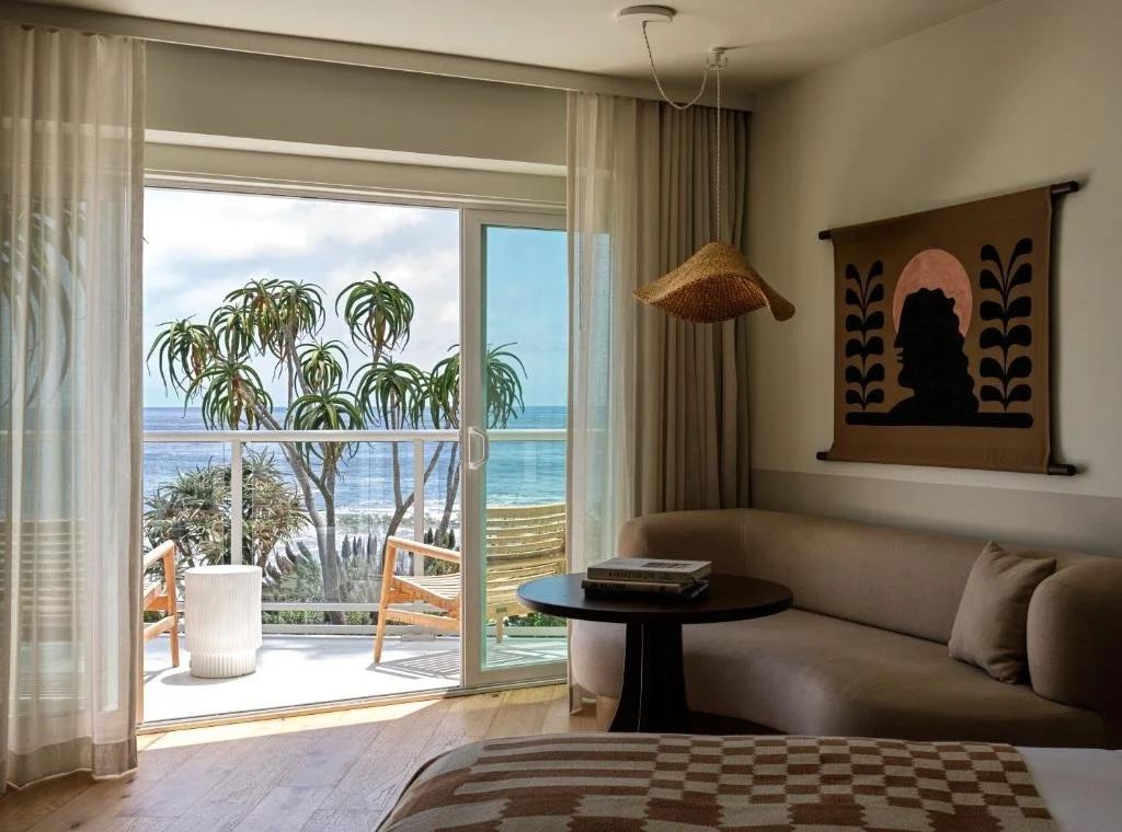 Casa Loma Beach Hotel Laguna Beach room interior with sliding glass door opening to ocean-view balcony with wood deck chair