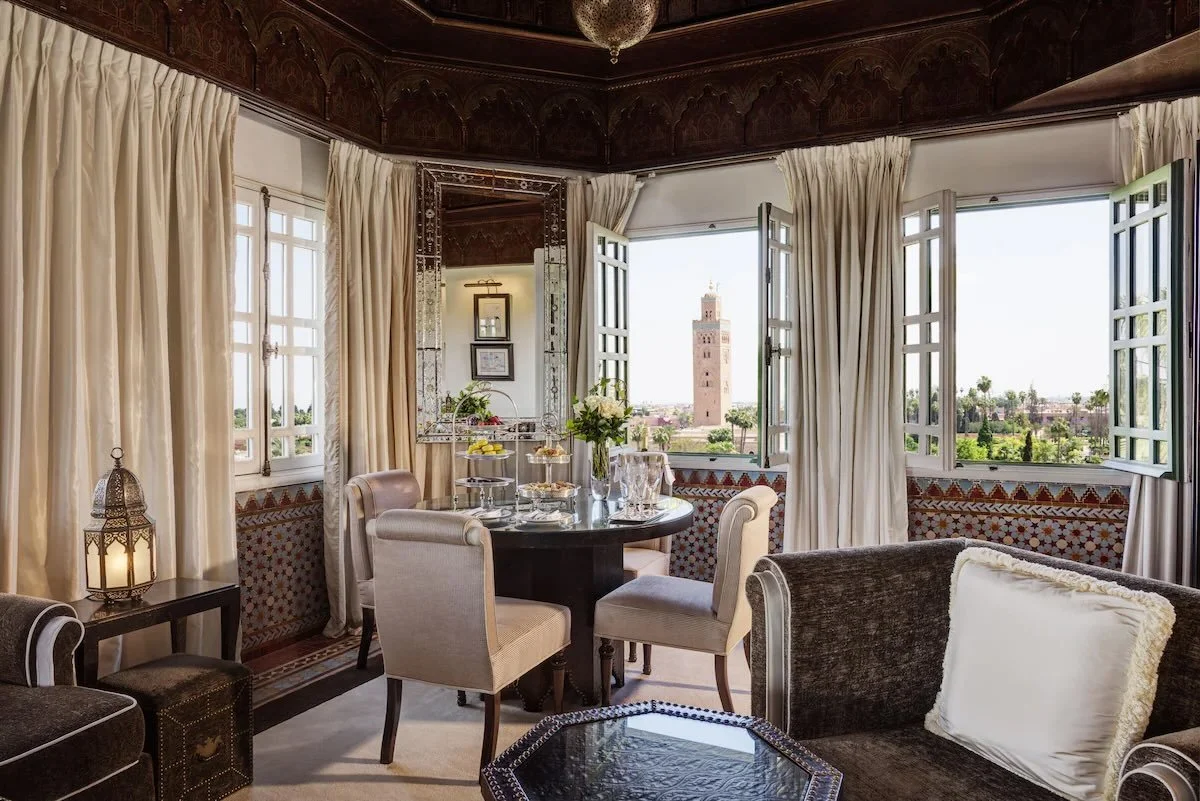 La Mamounia Marrakech ornate suite interior with open bay windows directly framing the Koutoubia Mosque minaret