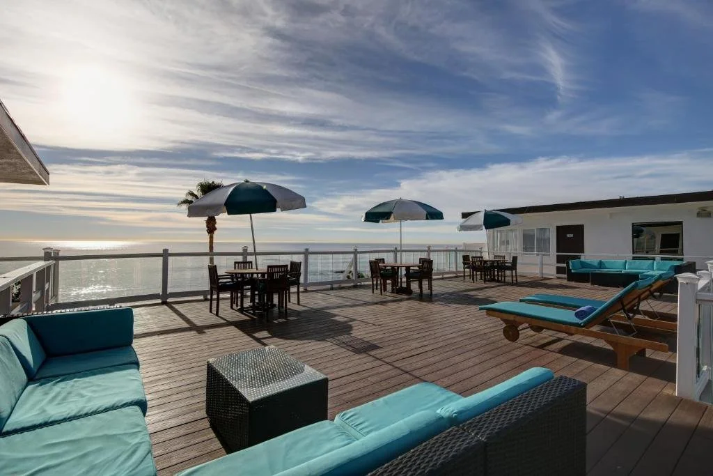 Capri Laguna on the Beach Laguna Beach rooftop terrace with teal outdoor furniture and Pacific Ocean panorama