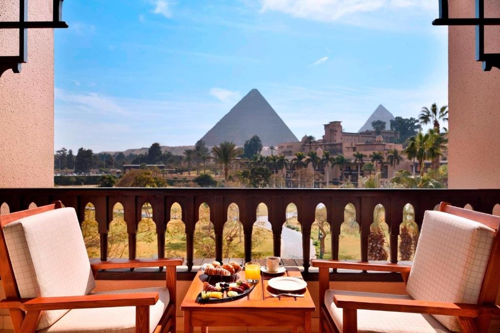 Marriott Mena House Cairo breakfast balcony with Great Pyramid of Khufu and Pyramid of Khafre framed through Moorish arch railing