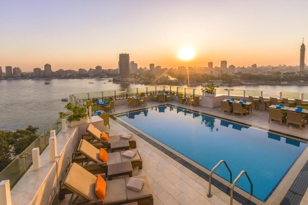 Kempinski Nile Hotel Cairo rooftop pool at sunset with Cairo Tower and Nile River in background