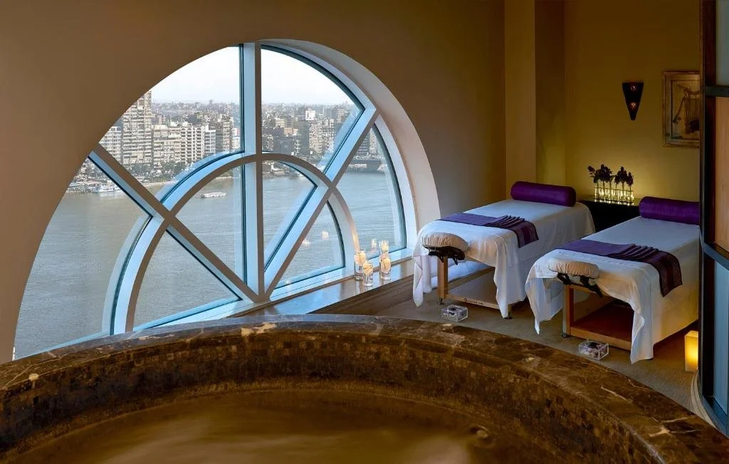 Four Seasons Cairo First Residence spa treatment room with circular arch window overlooking the Nile and city skyline