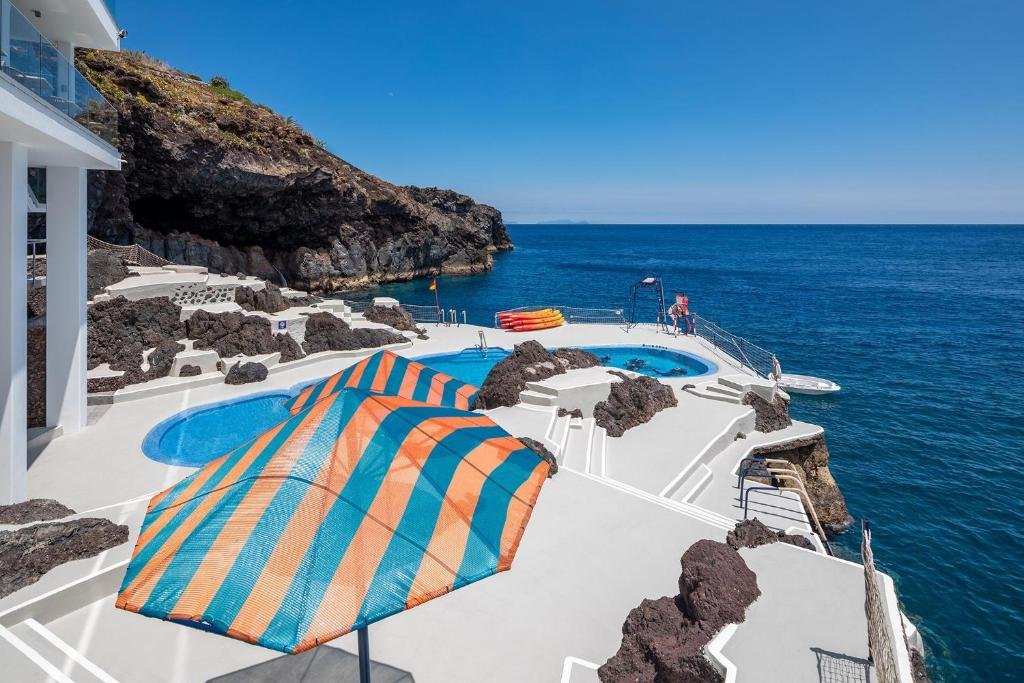 Sentido Galosol Caniço de Baixo sea terrace and volcanic rock pools with kayaks on the Atlantic coast