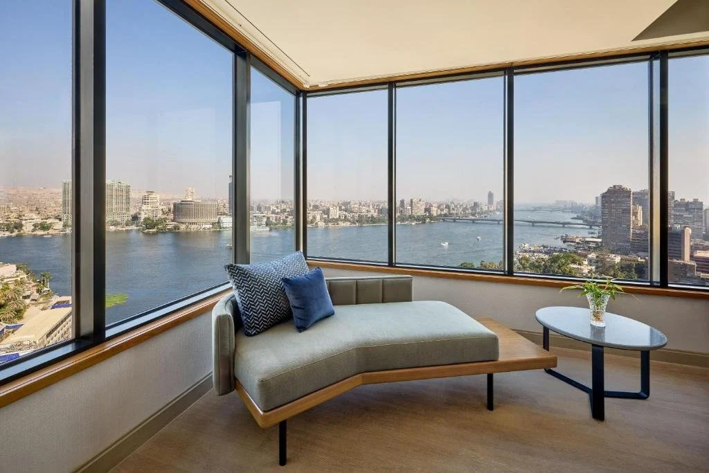 Sheraton Cairo Hotel corner suite with wrap-around floor-to-ceiling windows showing panoramic Nile River view and Zamalek island