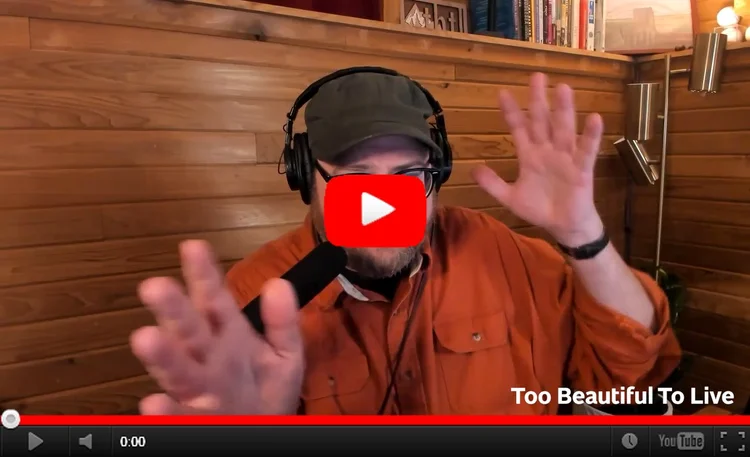 Still image from YouTUbe of Andrew talking in his studio,  his hands gesticulating wildly.