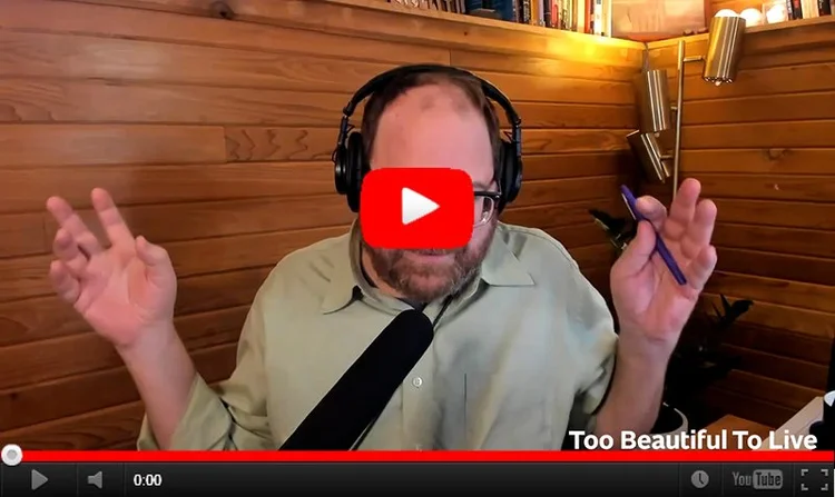 YouTube still image of Andrew in his studio, talking and gesticulating with his hands.